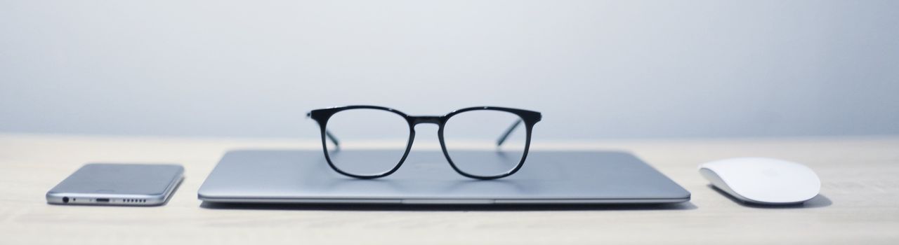 Eine Brille liegt auf einem geschlossenen Laptop (Symbolbild)